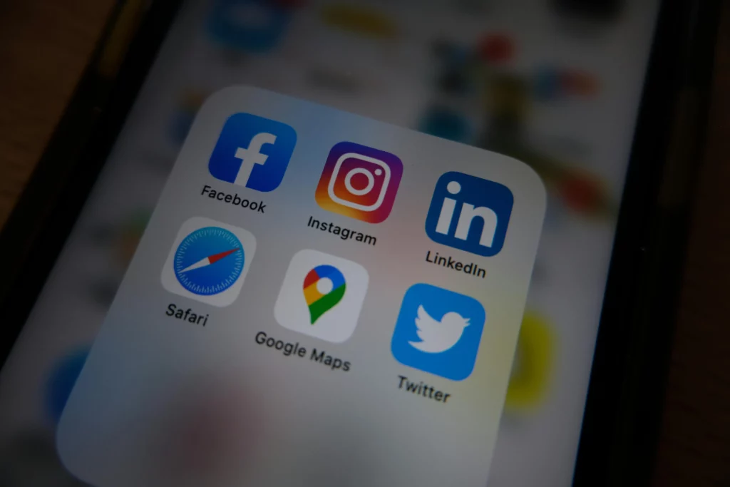 Close-up van een smartphone-scherm met iconen van Facebook, Instagram, LinkedIn, Safari, Google Maps en Twitter