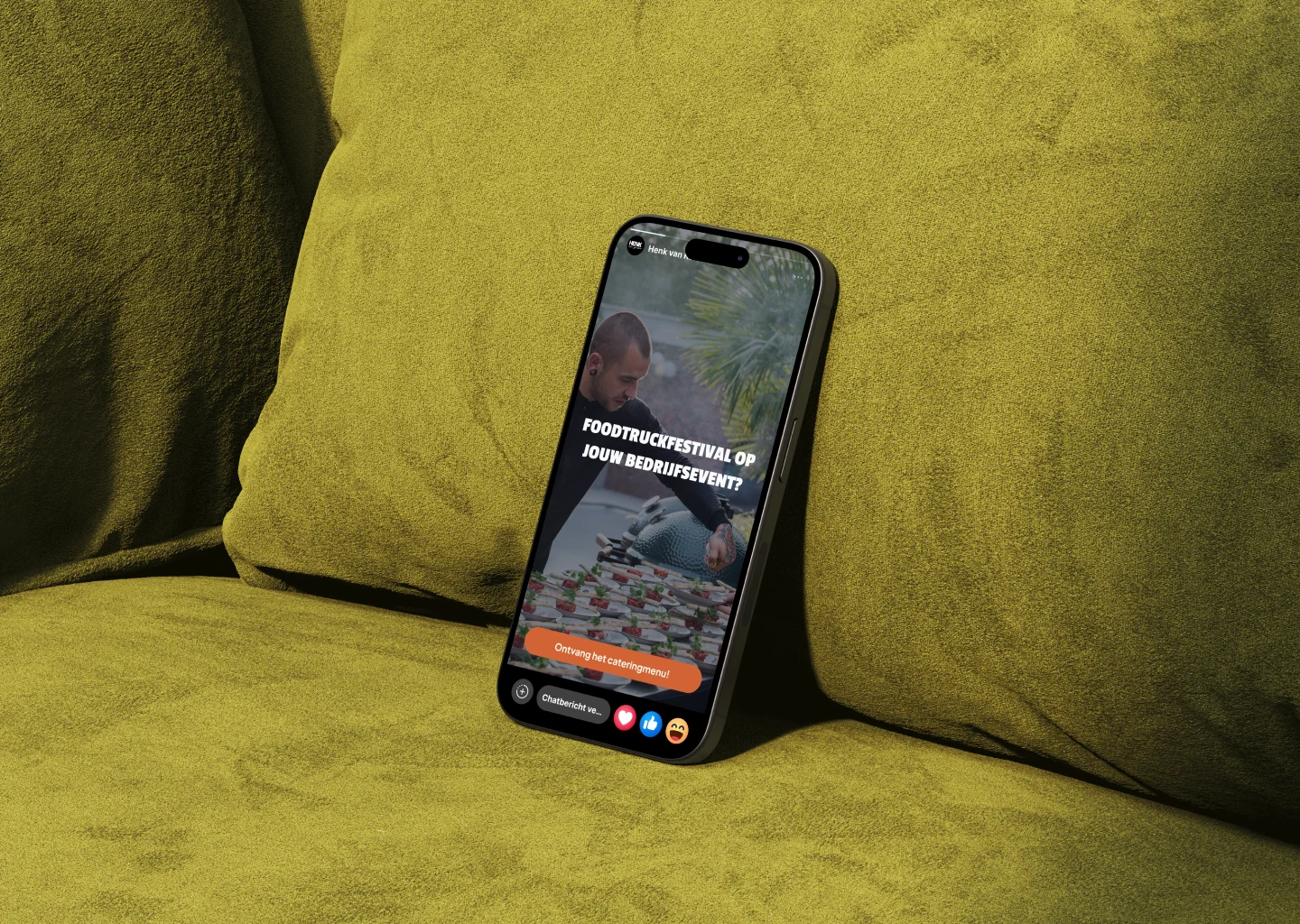 Smartphone leunend tegen groen kussen, scherm toont tekst over foodtruckfestival cateringmenu