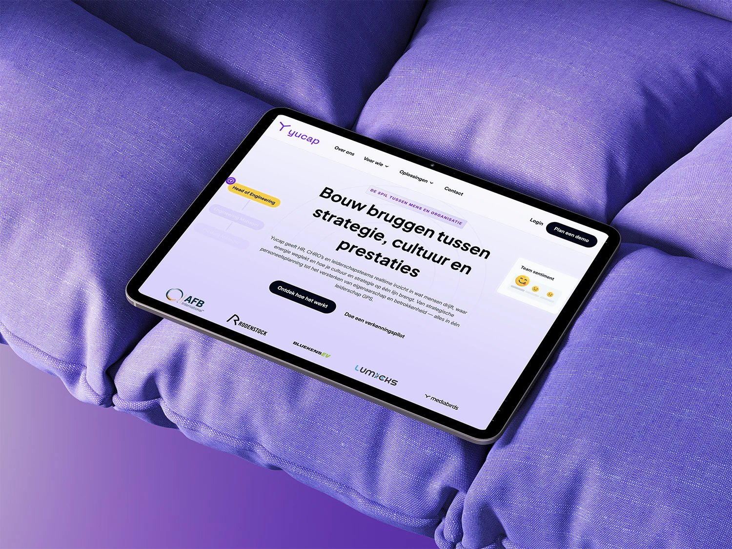 Tablet op paars kussen met websitegetiteld 'Bouw bruggen tussen strategie, cultuur en prestaties'.